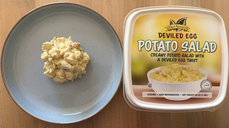 potato salad on blue plate next to plastic container