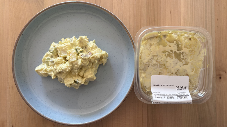 potato salad on blue plate next to plastic container of potato salad