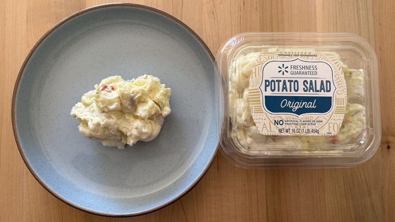 potato salad on blue plate next to plastic container of potato salad