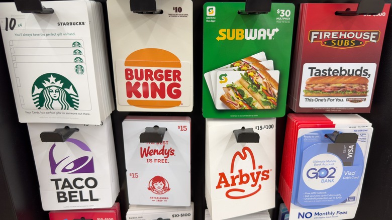 A rack of various fast food gift cards in a store