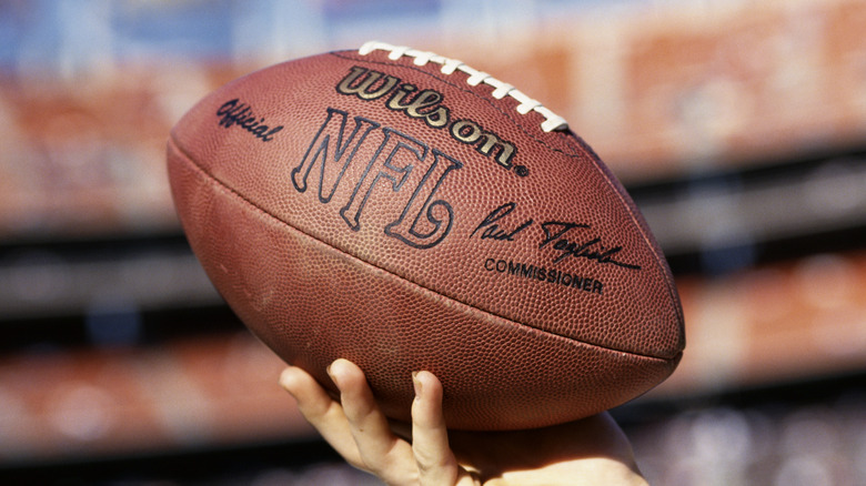 Hand holding up NFL football