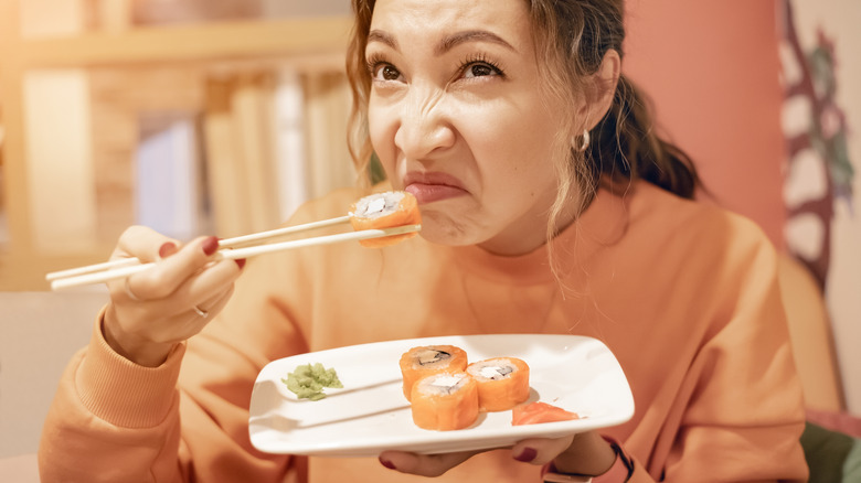 Woman is repulsed by bad smelling fish