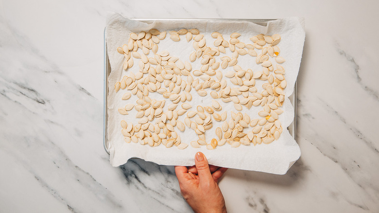 Dried pumpkin seeds on baking sheet