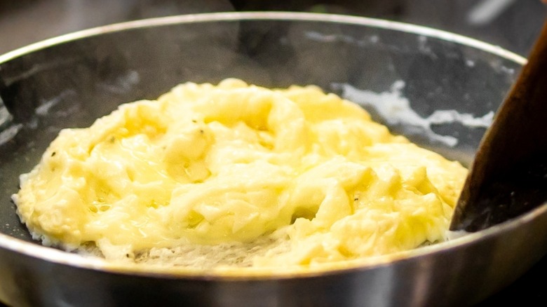 Scrambled eggs cooking in a frying pan