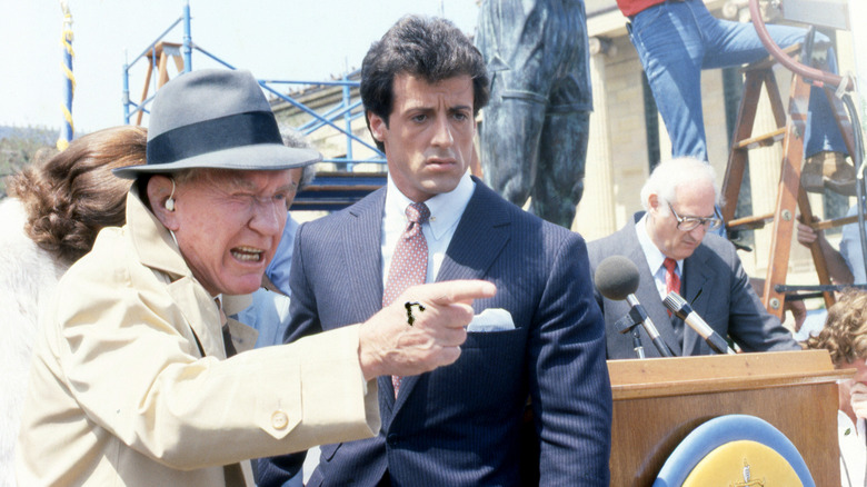 Sylvester Stallone as Rocky Balboa and Burgess Meredith as Mickey Goldmill standing together in Rocky III.