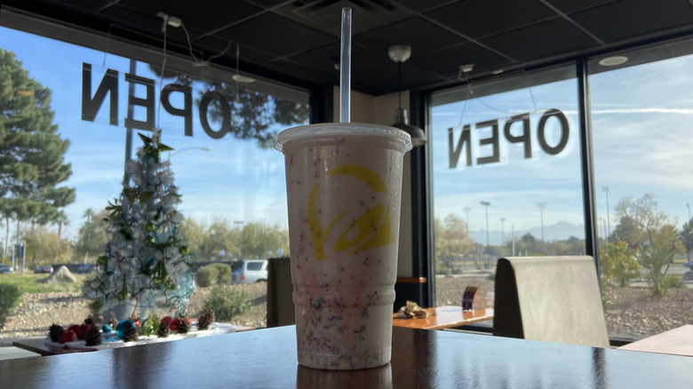 the Confetti Cookie Freeze on a Taco Bell table near a Christmas tree