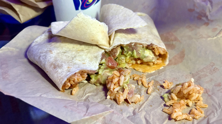 A 7-Layer Burrito split in half on top of its wrapper