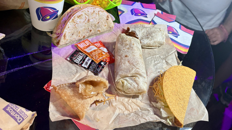 Five items from Taco Bell in a group next to Taco Bell napkins and a Taco Bell cup