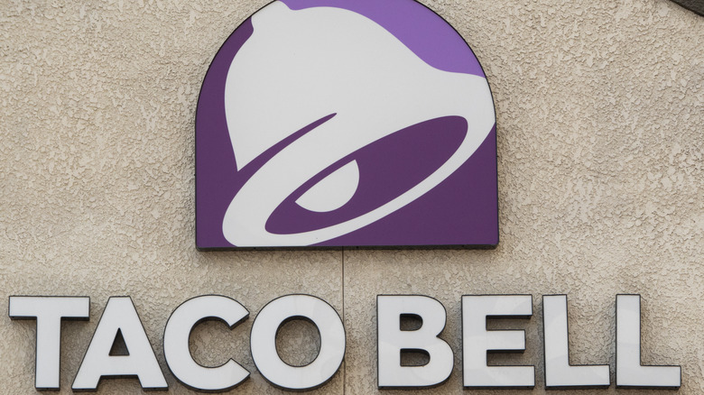 A Taco Bell logo sign on a beige wall