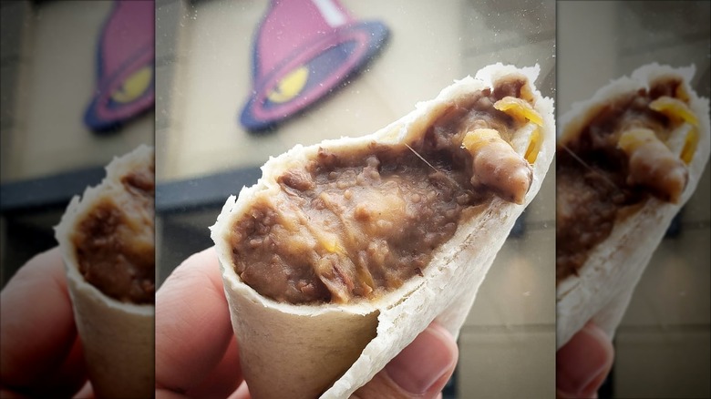 Hand holding Taco Bell bean burrito