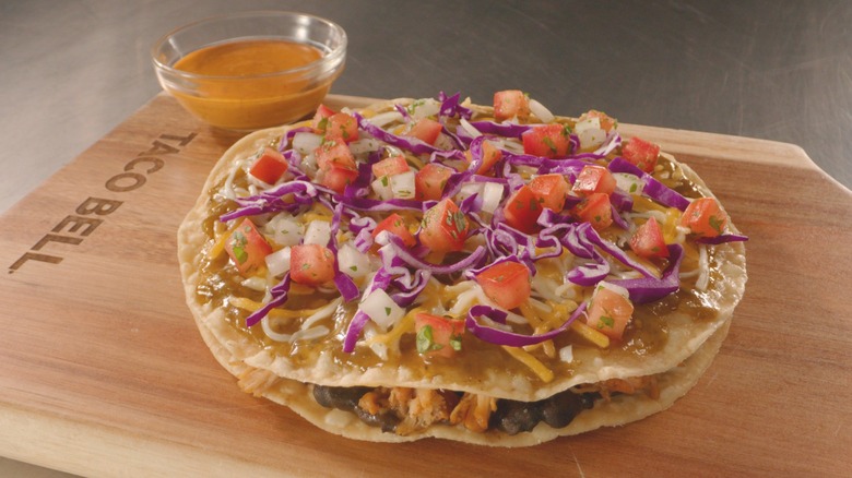 Taco Bell's Cantina Chicken Mexican Pizza with Jalapeño Citrus Salsa on wood board