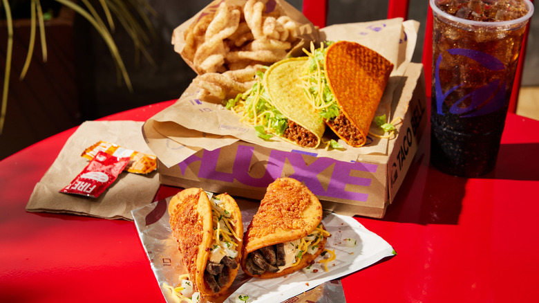 Taco Bell's Cheddar Street Chalupas Luxe Box meal on a red table