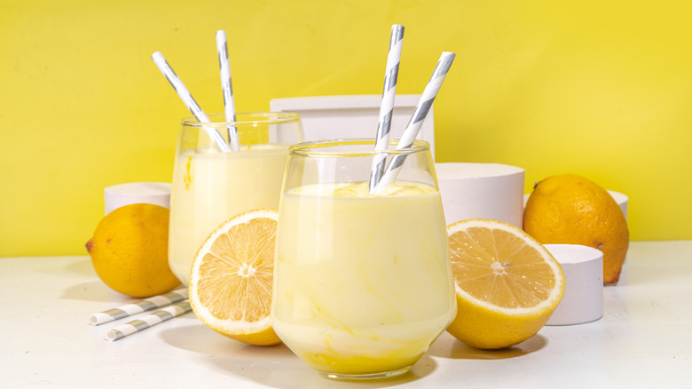Frozen lemonade in glass and halved lemons