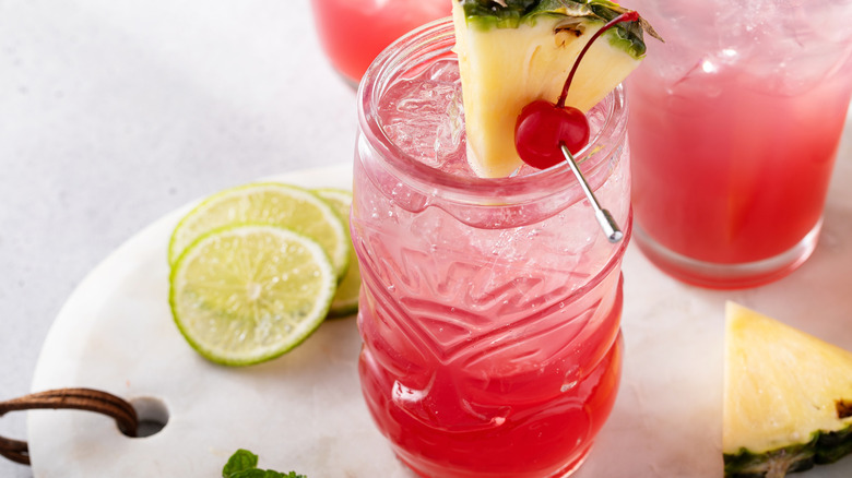 Singapore Sling cocktails with pineapple and cherry garnish