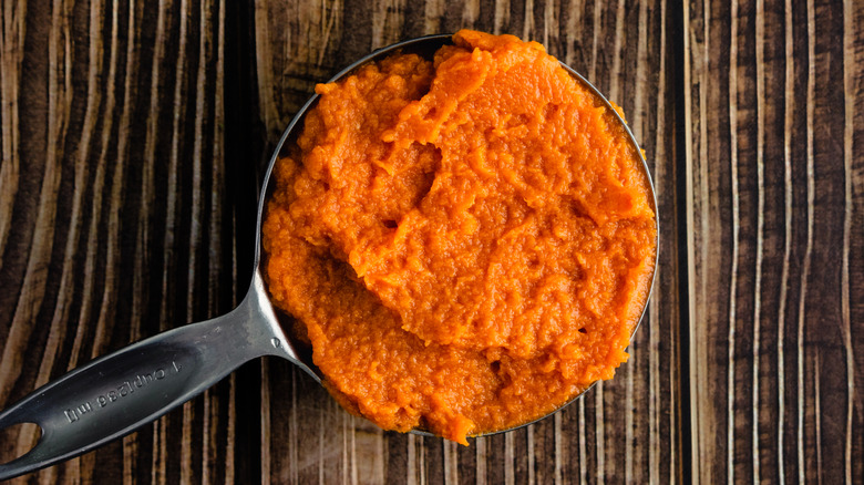 A measuring cup full of pumpkin purée