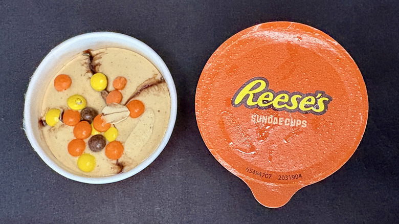 Top down view of an open Reese's mini ice cream cup next to a cup with the lid on