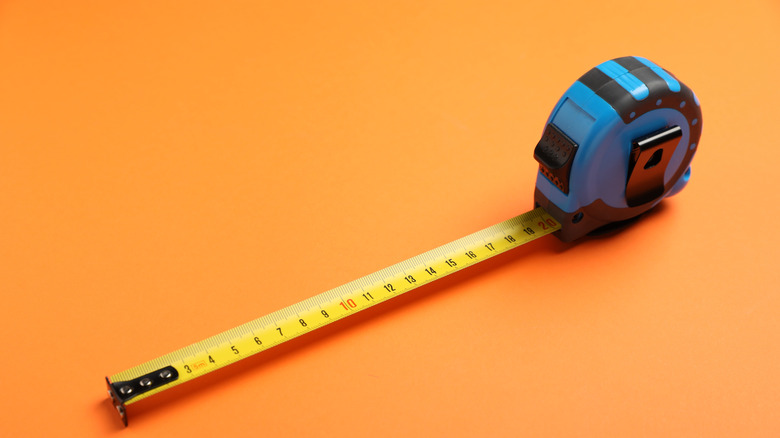 Measuring tape on orange background