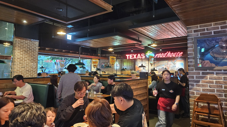 Worker walking through busy Texas Roadhouse restaurant