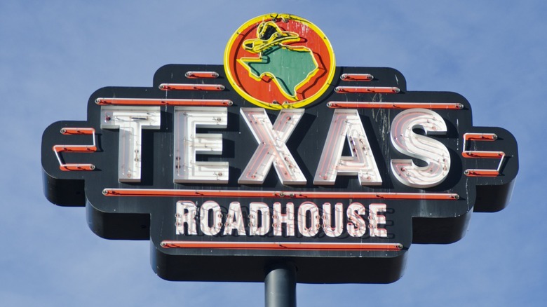 Texas Roadhouse sign against a blue sky background.