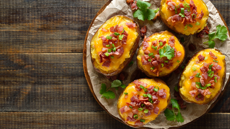 A row of perfectly cooked potato skins on a wooden board
