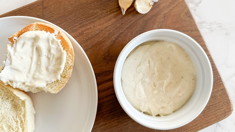 bowl of donkey sauce next to bun slathered with condiment