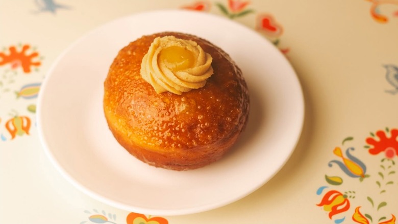 A baba au rhum Bismarck donut on a white plate from Dulce Dough Donuts & Bakery in Georgia