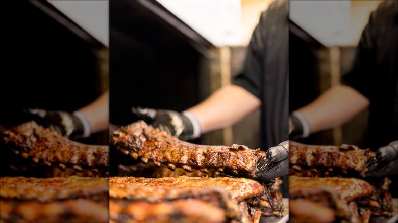 Worker at Pappy's Smokehouse ribs taking them out of the oven