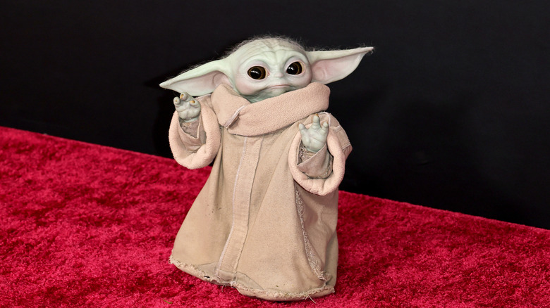 The figure of Grogu on a red carpet
