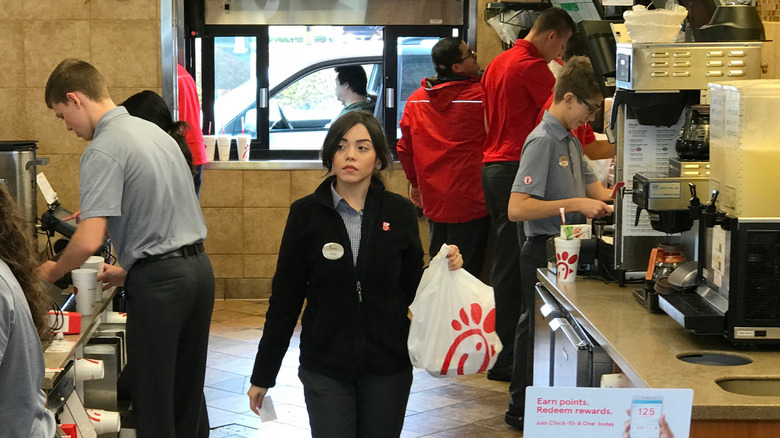 Chick-fil-A employees working behind at the counter at one of the chain's restaurants.