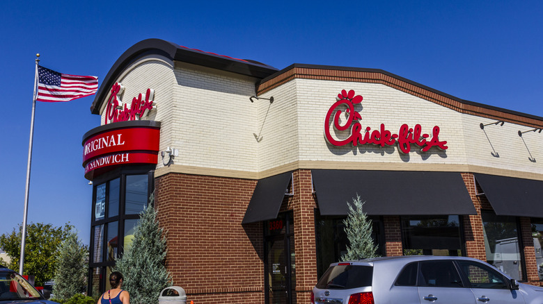 A car sitting on the side of a Chick-fil-A restaurant.