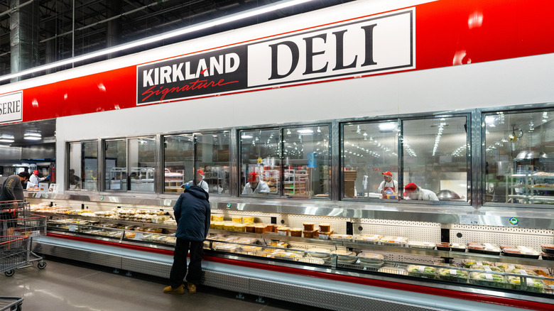 Customer checks out options from the premade meals from the refrigerated deli section at Costco.