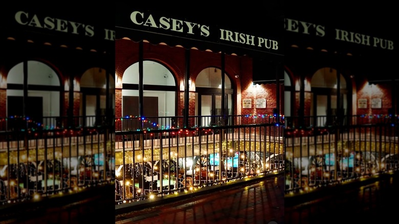 Exterior of Casey's Irish Pub at night in Los Angeles, string lights around railing