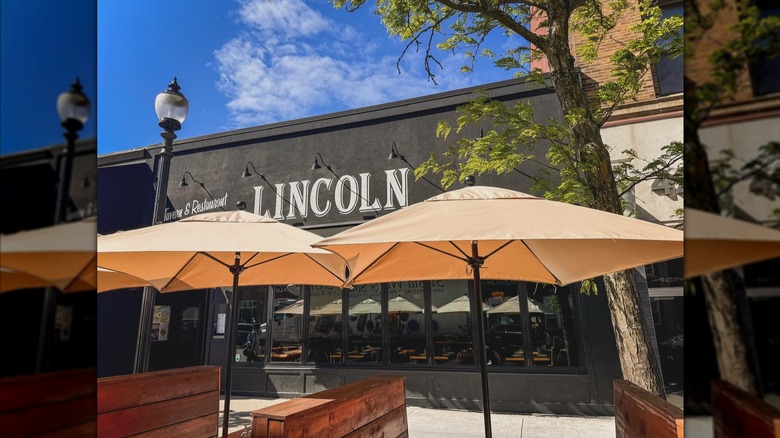Exterior of Lincoln Tavern and Restaurant with big umbrellas over benches and tables on patio