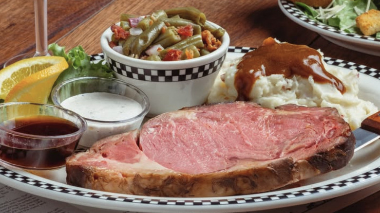 A plate of slow roasted prime rib with sides