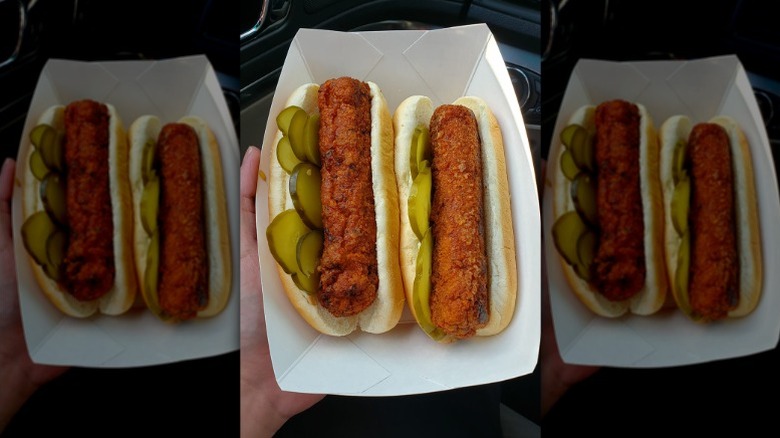 Two Kwik Trip rollerbites in a hot dog bun with pickles.