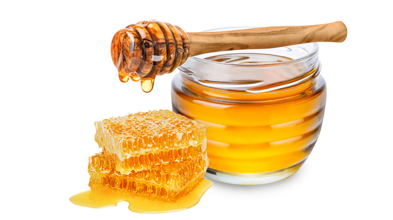 Honey in a clear jar and honeycomb