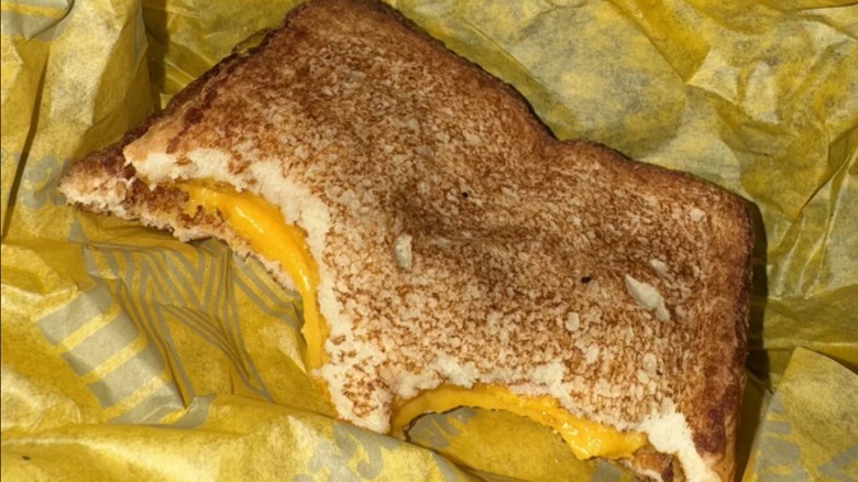 A grilled cheese sandwich from Whataburger with several bites eaten out of it