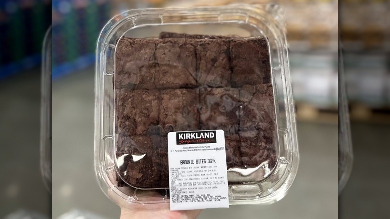 a hand holds a package of Costco Kirkland Signature brownies up to the camera