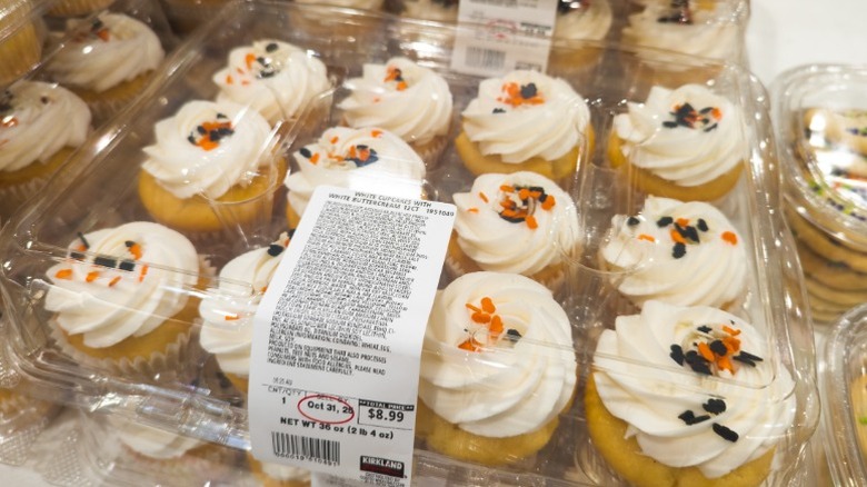 clear clamshells holding Costco vanilla cupcakes with orange and black sprinkles