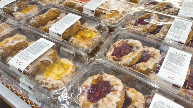 a shelf of clamshells holding Costco fruit and cheese danishes