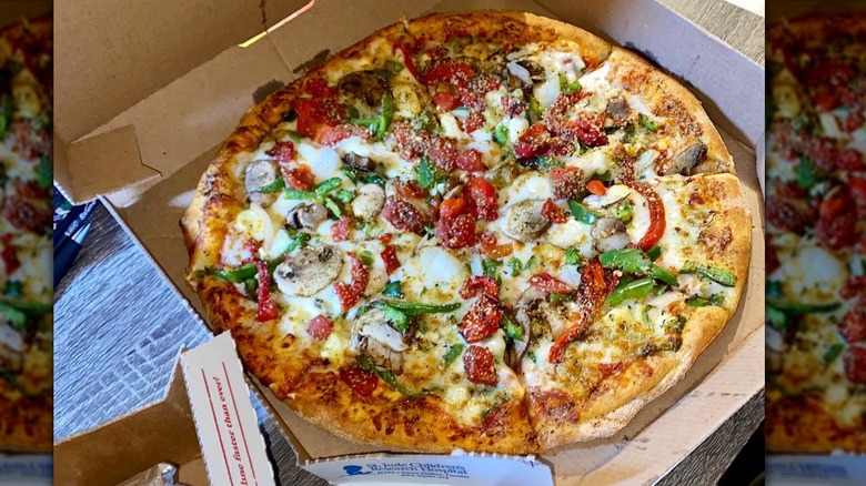 Dominos pacific veggie pizza in an open cardboard carryout box