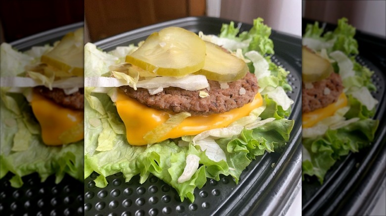 McDonalds burger with no bun on a to-go plastic tray