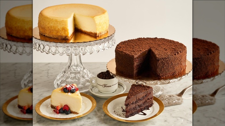 Cheesecake and Chocolate cake on display on glass cake stands, and cut slices on plates at Ferrara Bakery & Cafe in New York City