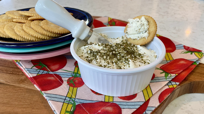 A tub of Alouette cheese spread served with crackers