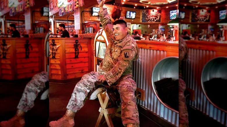 A customer, who is part of the military, sitting on Texas Roadhouse's birthday saddle.