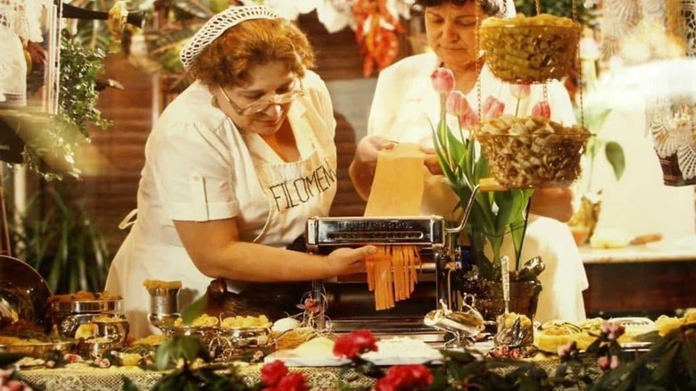 Two women with Filomena aprons making handmade pasta noodles at Filomena Ristorante