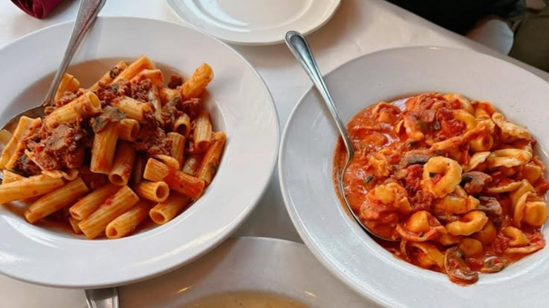 Two pasta dishes from Mart Anthony's Italian Restaurant in white bowls, one with rigatoni noodles and one with tortellini, both in a red sauce