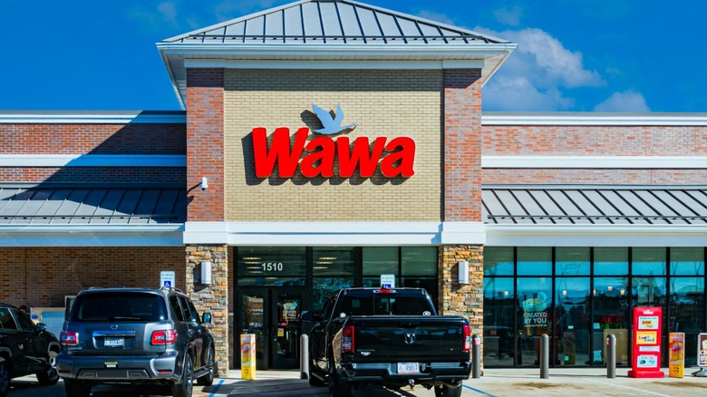 Outside of a Wawa convenience store and gas station with cars parked in front