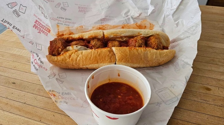 Wawa meatball parmesan hoagie with a cup of soup or marinara sauce