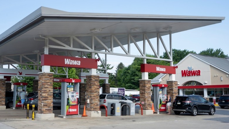 People pump gas at a Wawa gas station